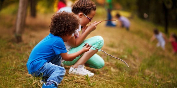 Two young boys inspecting twigs