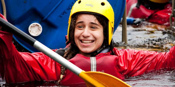 Teenage girl smiling after falling our of a canoe